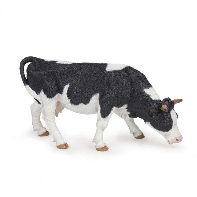 Black and white grazing cow figurine