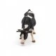 Black and white grazing cow figurine