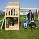 Голяма Детска Дървена Къщичка GINGER HOME за Двор с Пързалка, 2 Люлки, Катерушка и Пясъчник – 250×150×267 см