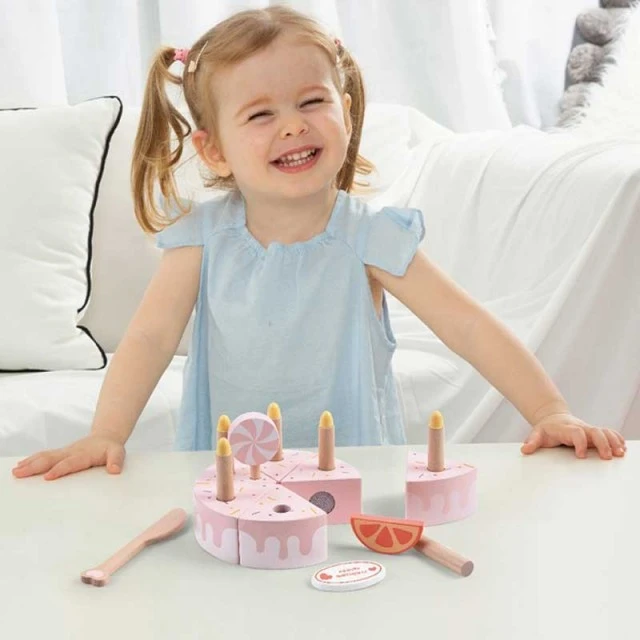 Children’s cake made of wood with pastel pink candles