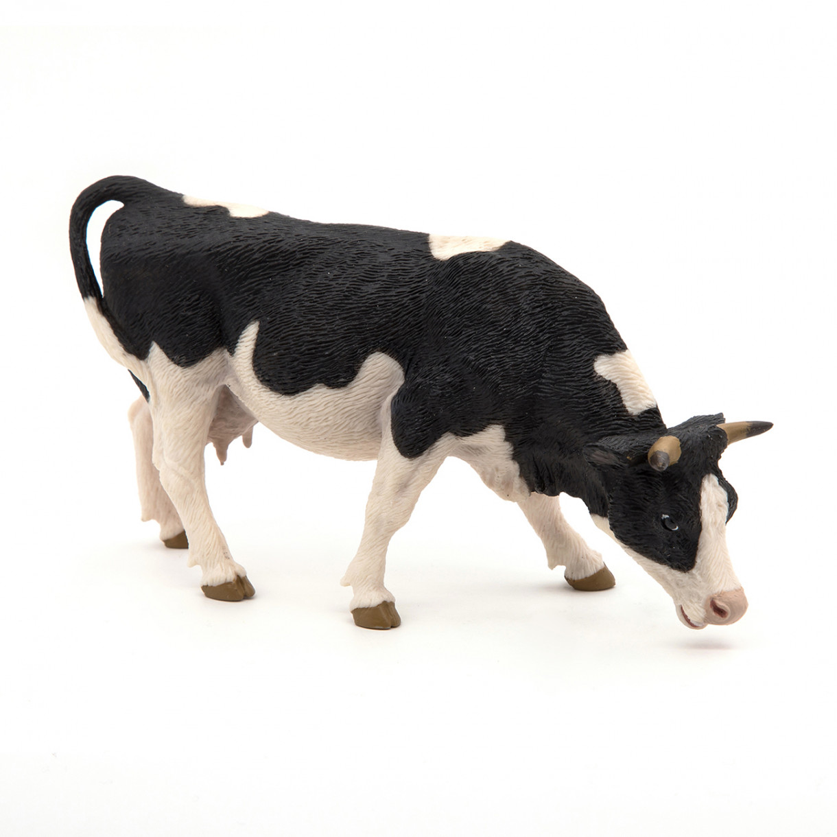 Black and white grazing cow figurine